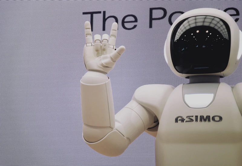 Bijeli humanoidni robot podignute ruke u izložbenom prostoru